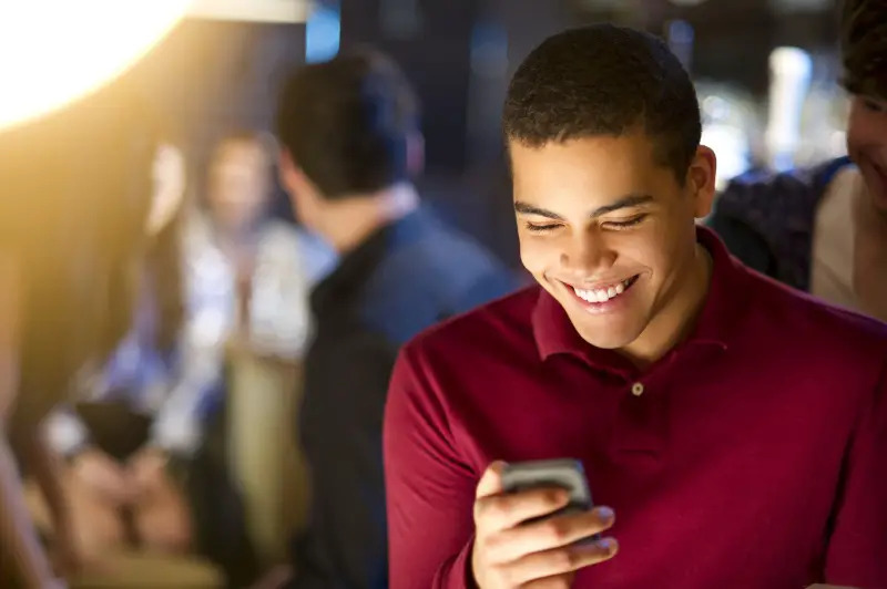 boy holding phone and smiling