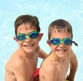 boys in goggles; young boys, brothers swimming at the pool
