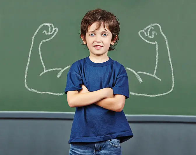 boy in front of blackboard with muscles
