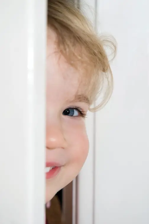 child peeking through door