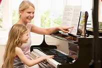 child playing piano with instructor