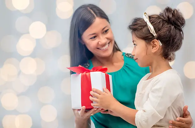 child receiving gift from mom