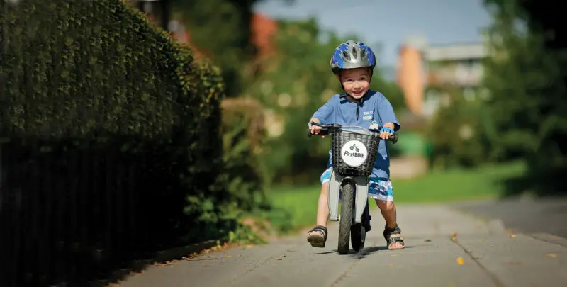 child riding balance bike