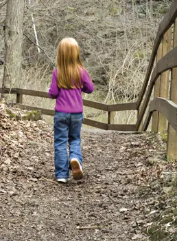 little girl walking in the woods during fall; child on nature walk