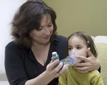 child with asthma using inhaler