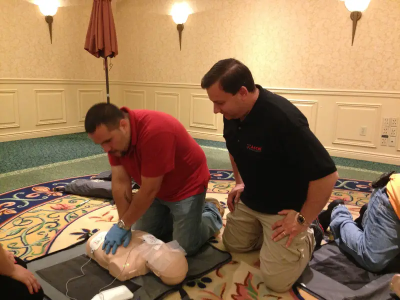 man practices cpr with aed