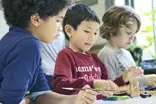 kids creating jewelry in a metalworking class