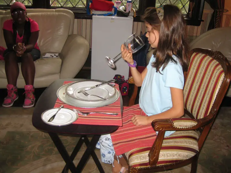 young girl learning dining room etiquette