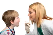 doctor examines child's throat