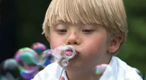 boy with down syndrome blowing bubbles