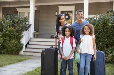 family-outside-home-luggage