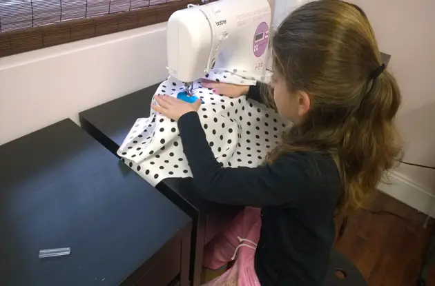 girl sewing clothing