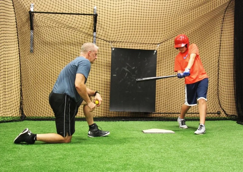 boy in batting cages at fenom fitness