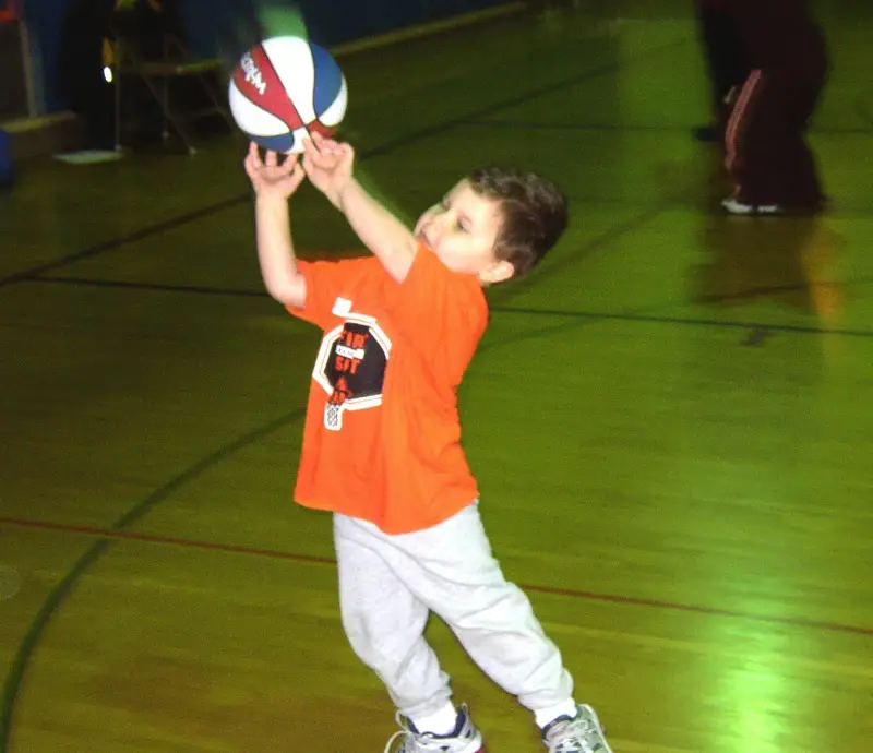 young boy shooting basketball