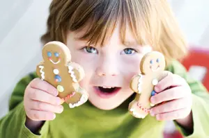 little girl holding gingerbread cookies
