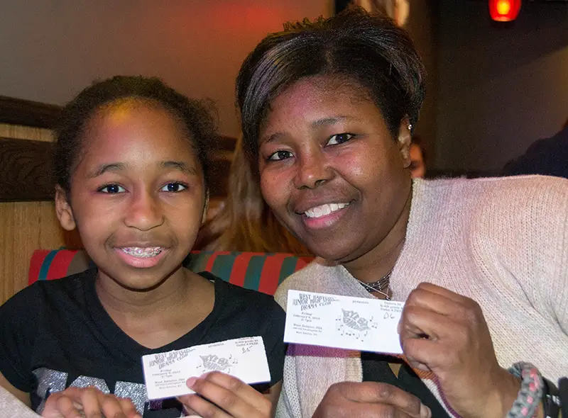 mother and daughter posing with tickets