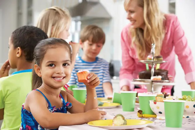 Girl at party eating cupcake