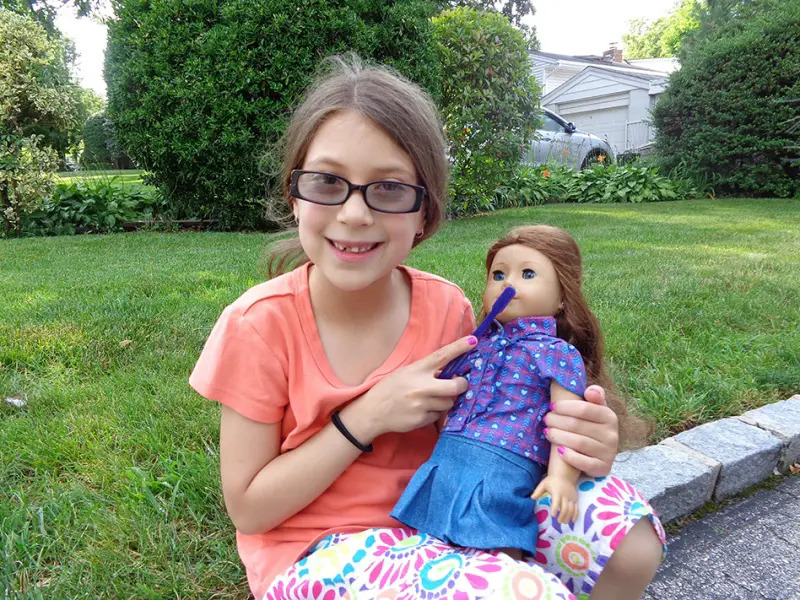 girl brushing american girl doll's teeth