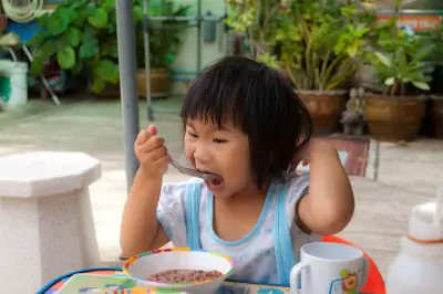 girl eating cereal outside