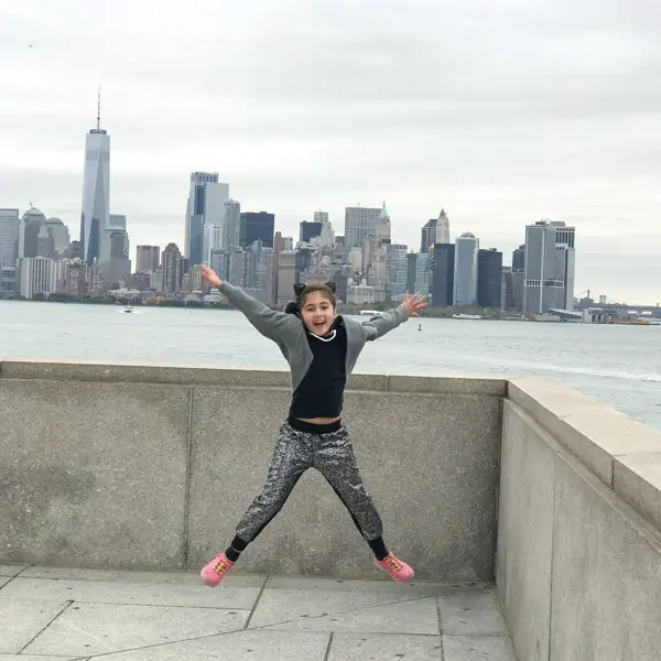 globetrottingmommy girl jumping nyc skyline