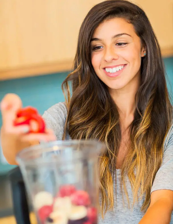 teen girl making fruit smoothie