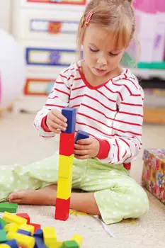 little girl playing with blocks; special needs child