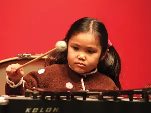 young girl playing the xylophone