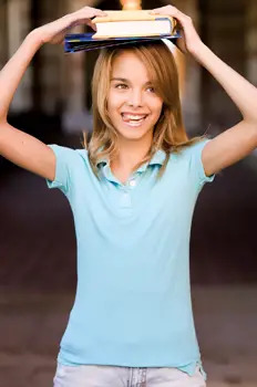 teenage girl practicing her posture by balancing books on her head