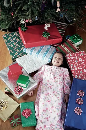 girl surrounded by presents on christmas