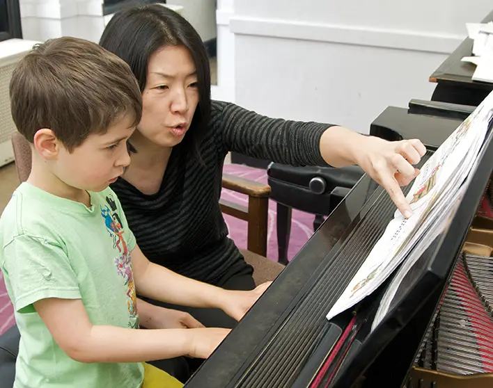 child and teacher at piano