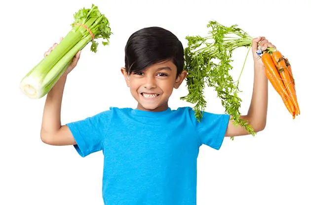 happy boy holding vegetables