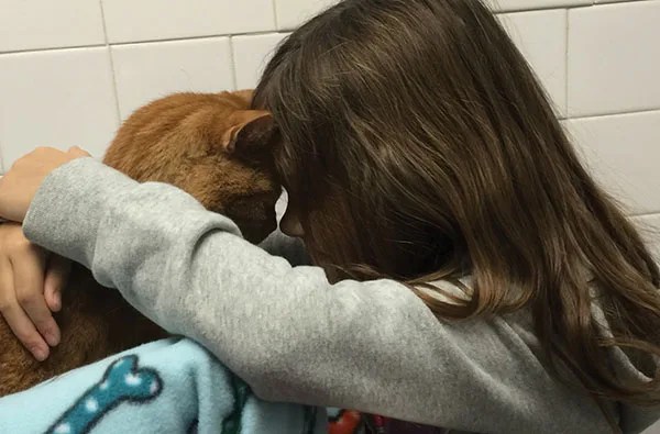 girl cuddling cat