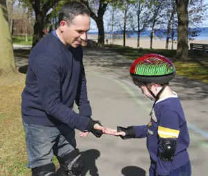 dad and son high five while rollerblading