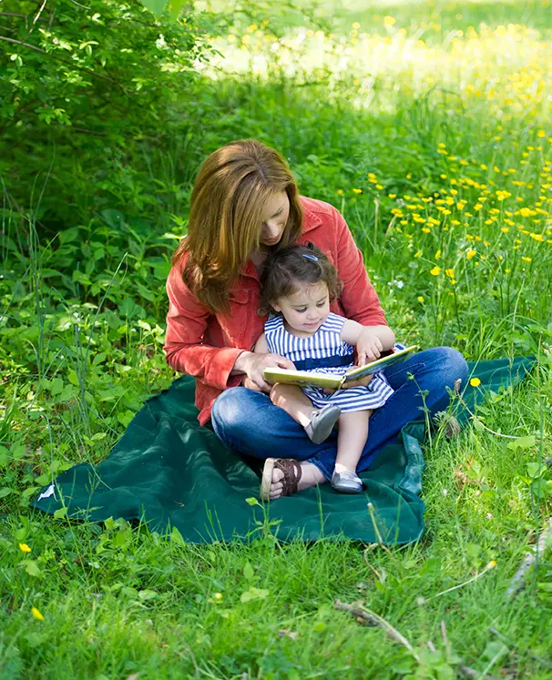 mother and child reading outside