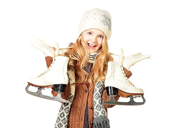 young girl holding ice skates