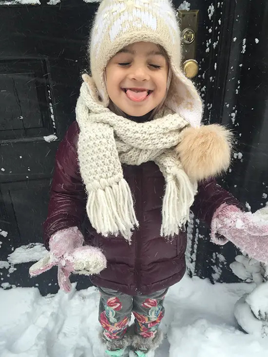 girl catching snow on tongue