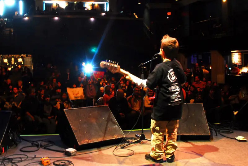 Courtesy Bach To Rock child playing guitar on stage