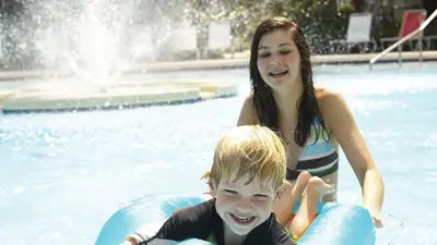 kids playing in the pool; family vacation; sister and brother in pool