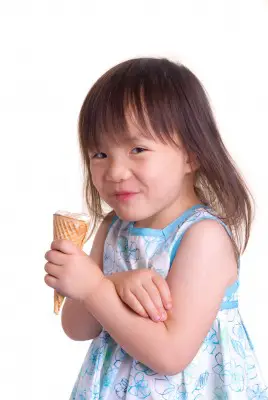 little girl in summer dress eating ice cream cone