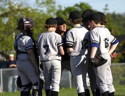 little league team in huddle with coach
