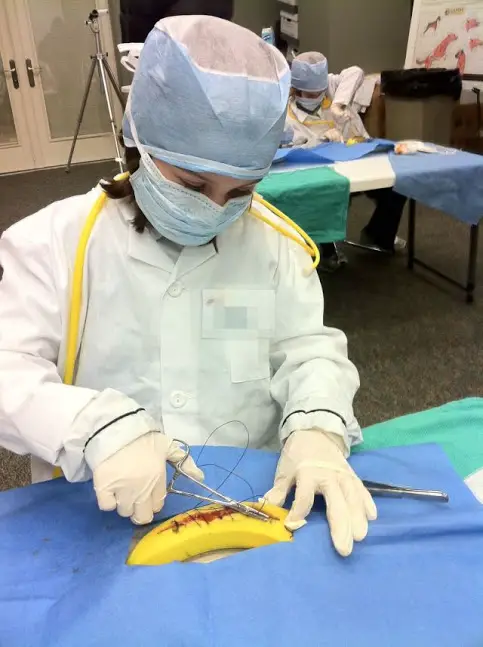 child practicing stitches on banana
