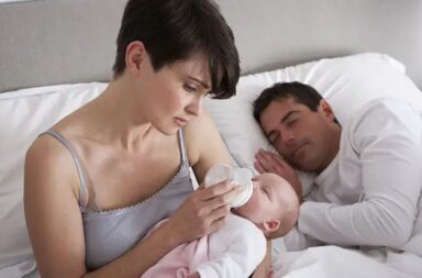 mother-feeding-baby-dad-sleeping