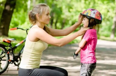 mother-putting-bike-helmet-on-child