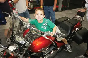 child at motorcycle show; little boy sitting on motorcycle