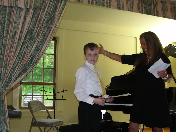 Student stands for applause after his portion of the recital. Music Academy for Special Learners Annual Recital