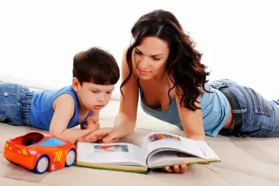 nanny with young boy reading a book