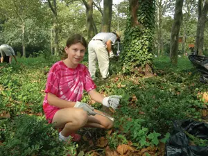 park volunteer; young girl helping clean up a park