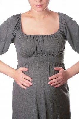 pregnant woman in dress holding stomach