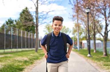 Great,Portrait,Of,School,Pupil,Outside,Classroom,Carrying,Bags