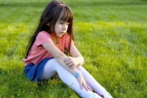 sad girl sitting on grass